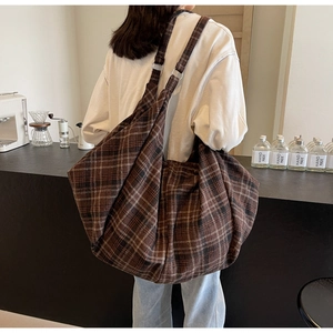 Détail d'un grand sac cabas à carreaux marron en toile avec des bandoulières solides
