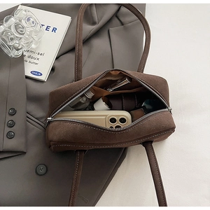 Detailed top view of brown suede underarm bag showing spacious interior and zip closure