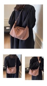 Détail macro du sac à bandoulière en daim rose poudré avec décoration de nœud élégante