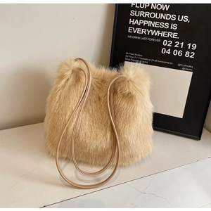 Vue détaillée du sac à bandoulière en fausse fourrure beige sur surface marbre