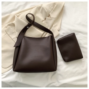 Detail shot of a dark brown minimalist tote bag with matching small zippered clutch set