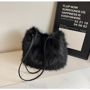 Sac à épaule chic en fausse fourrure noire avec lanières en cuir sur surface en marbre