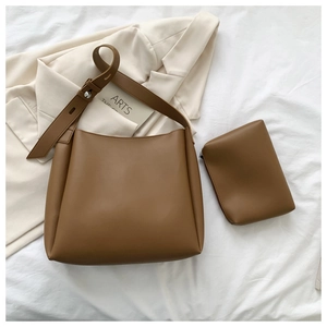 Caramel brown leather tote set showing large bucket bag and matching zipper pouch details