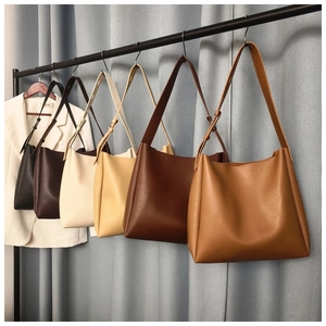 Row of minimalist hobo bags in six colors hanging against a blue backdrop