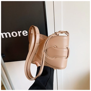 Detail of camel leather bucket bag with braided shoulder strap and matte finish