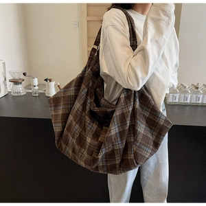 Détail du grand sac cabas à carreaux avec large bandoulière et texture en toile tissée