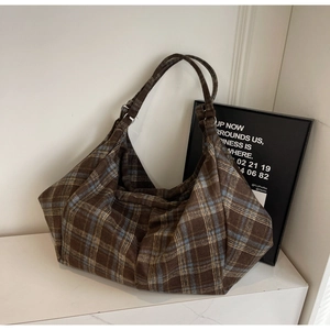 Détail du sac cabas à carreaux bleu et marron avec grande capacité et texture rétro