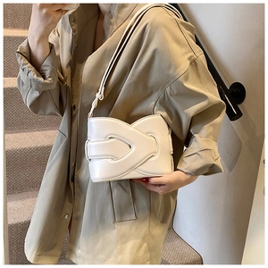 Detailed shot of white vintage bucket bag with elegant leather fold texture and strap