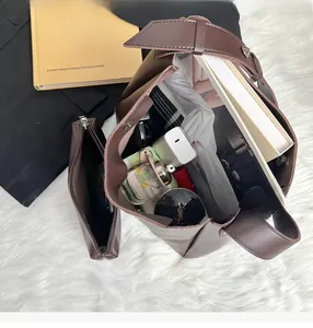 Top view of large brown tote bag showing spacious interior with books and pouch