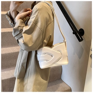 Detail view of white faux leather crossbody bag with geometric interlocked texture