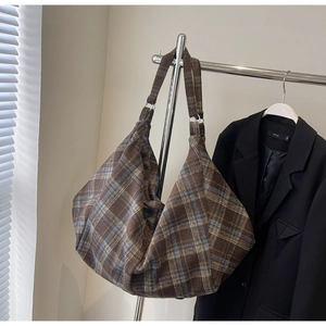Détail du sac hobo en laine tartan avec large bandoulière et garniture métallique