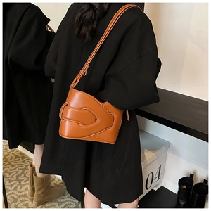 Detail of layered woven design on orange-brown leather bucket bag for women