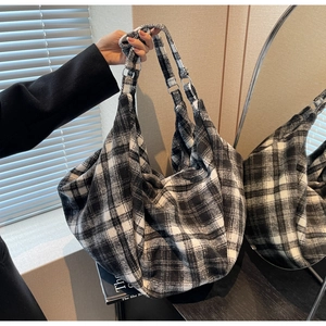 Détail d'un sac cabas à carreaux noir et blanc en laine épaisse avec boucles métalliques