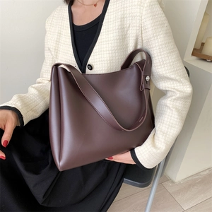 Minimalist dark brown oversized tote bag in matte synthetic leather with wide strap