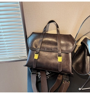 Detailed macro view of dark brown vintage leather handbag with gold metallic buckles