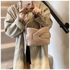 Detail view of a nude leather bucket bag featuring a unique cross-structured design