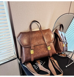 Detail of vintage brown leather backpack with dual buckle flap and light gold hardware