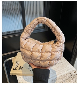 Vue détaillée du sac nuage matelassé champagne avec texture satinée douce et zip