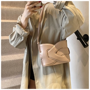 Detail shot of vintage beige bucket bag featuring unique cross-overlap buckle design