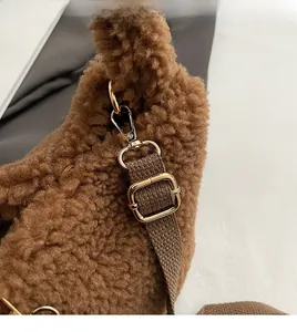 Detail of gold metal swivel hook and textured faux fur material on brown bucket bag