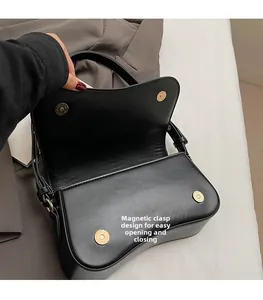 Détail de la double fermeture magnétique sur un sac selle noir avec intérieur ouvert