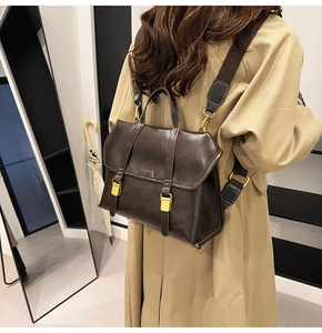 Close-up of vintage brown leather backpack showing flap buckle and high-quality stitching