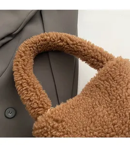 Detail of the cozy teddy plush handbag handle with golden metal ring hardware