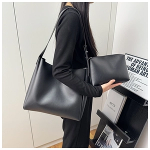 Detail view of the black leather tote bag and matching pouch with adjustable strap