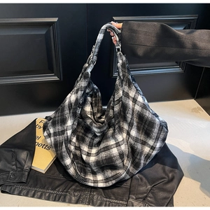 Gros plan du sac cabas en tweed à carreaux noir et blanc montrant la texture du tissu