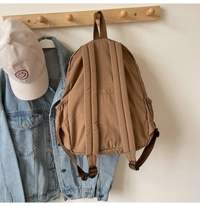 Back view of brown nylon casual backpack showing adjustable straps and side pocket detail