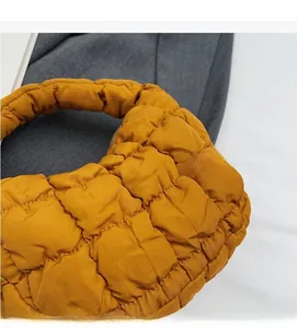 Gros plan du sac matelassé jaune moutarde avec un tissu texturé à carreaux doux
