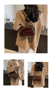 Detail view of dark brown patent leather shoulder bag with magnetic flap on a model