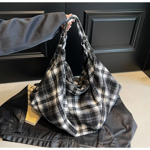 Détail de la texture en laine à carreaux noirs et blancs de ce grand sac cabas