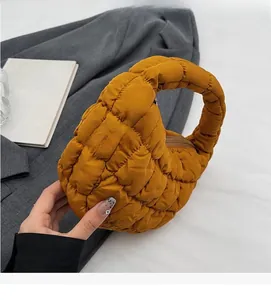 Gros plan détaillé d'un sac nuage matelassé jaune moutarde avec texture à damier gonflée