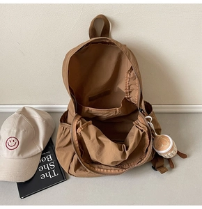 Detailed top view of brown nylon backpack interior with spacious main compartment and heart charm