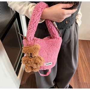 Detailed close-up of pink plush bucket bag texture with a cute brown teddy bear charm