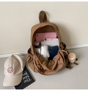 Internal view of the brown nylon backpack showing large storage capacity and compartments