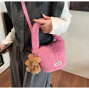 Detailed view of pink plush bucket bag with teddy texture and a cute brown bear charm