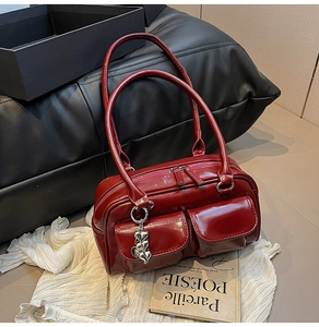 Detail of burgundy glossy tote bag featuring double front pockets and silver heart charms