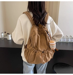 Brown lightweight backpack detail featuring drawstring design and cute plush coffee cup charm