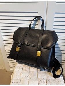 Classic black leather vintage backpack with white contrast stitching and top handle