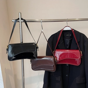 Glossy patent leather shoulder bags in black, dark brown and burgundy with asymmetric flaps