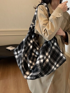 Sac fourre-tout à carreaux noir et blanc avec bandoulière réglable, porté par un mannequin