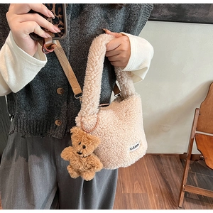 Detail of off-white faux fur bucket bag with adjustable strap and teddy bear charm
