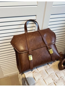 Vintage brown leather laptop backpack with dual brass buckles and woven strap
