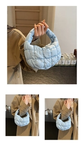 Gros plan sur le sac matelassé bleu clair montrant le tissu texturé et la forme croissant