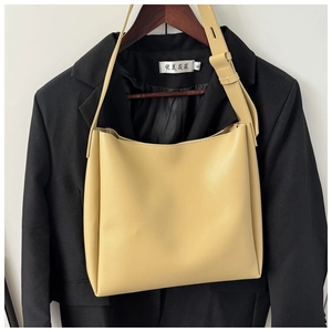 Detail view of a cream leather tote bag with adjustable shoulder strap and clean silhouette