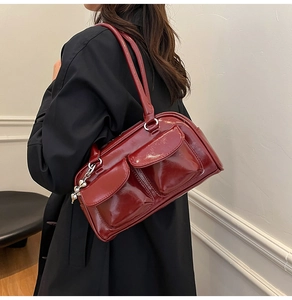 Detail of burgundy vintage tote bag with front flap pockets and heart metal charm