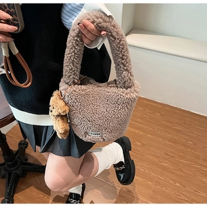 Brown faux fur bucket bag with a cute bear pendant and a white branded label