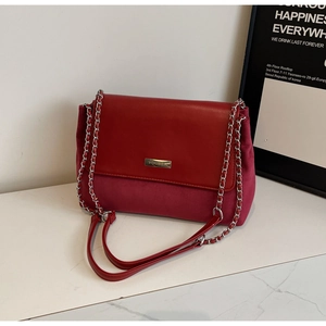 Close-up of red and burgundy leather underarm bag with metal chain strap and YOUBER logo